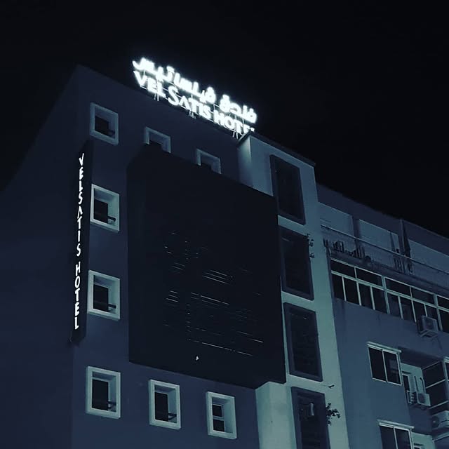 Velsatis hotel neon signage at night
